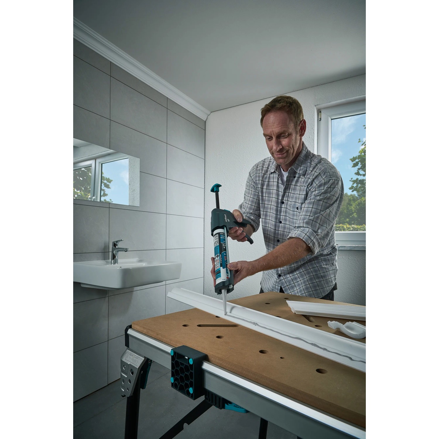 Mann benutzt wolfcraft Kartuschenpresse MG 600 Pro für Dichtarbeiten im Bad.