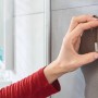 Tesa Powerstrips Haken Waterproof eckig Edelstahl Large an grauer Badezimmerwand.