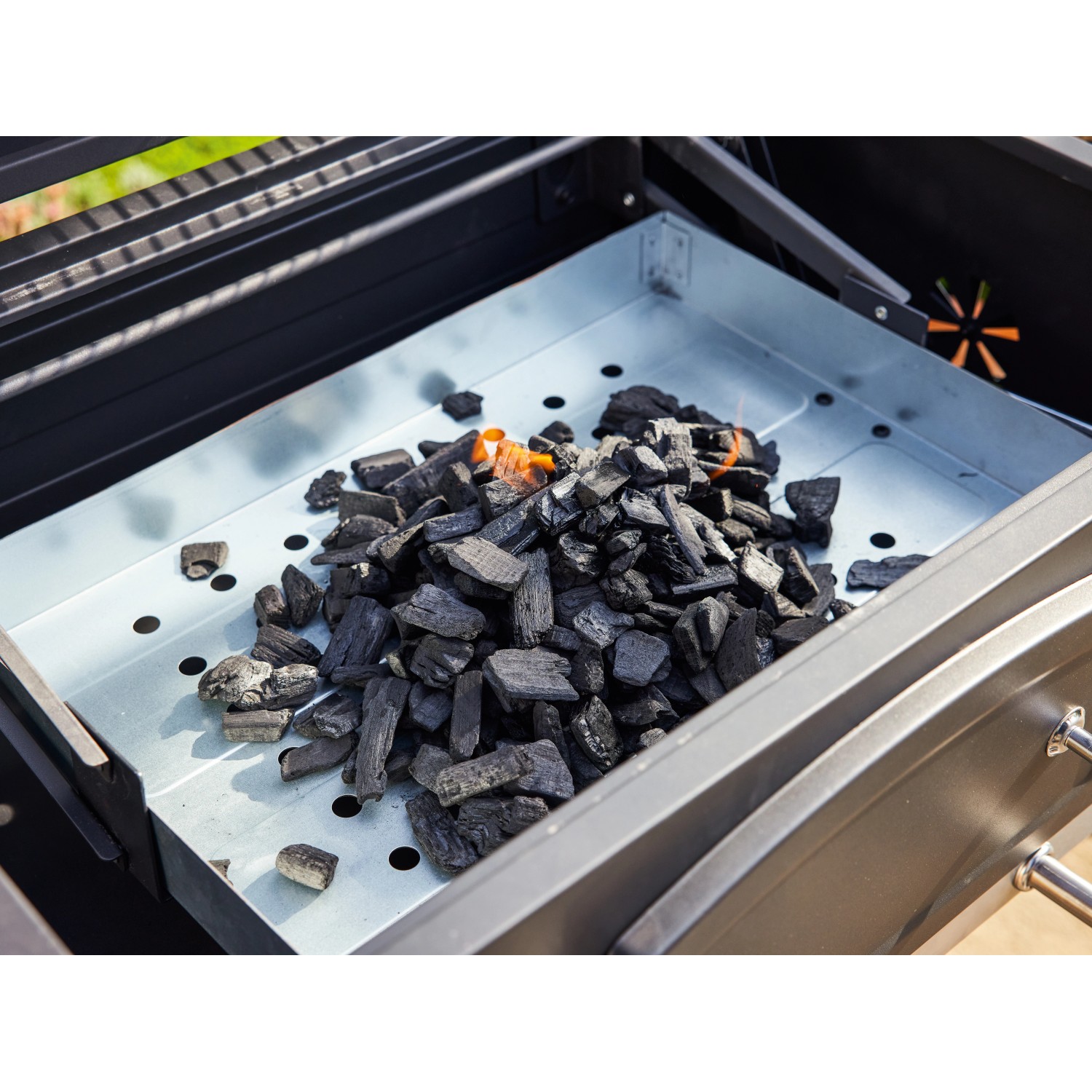 Holzkohle in der Kohlewanne des Jamestown Grillwagens Jaxon.