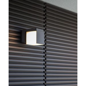 Moderne Lutec LED-Außenwandleuchte Cuba in Anthrazit mit warmweißem Licht an dunkler Holzwand.