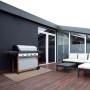 Wetterfester KARAT Outdoor Teppich Trani 180x450 cm auf Terrasse mit Grill und Gartenmöbeln.