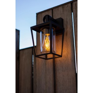 Schwarze Lutec Außenwandleuchte West mit Retro-Glühbirne an Holzwand.