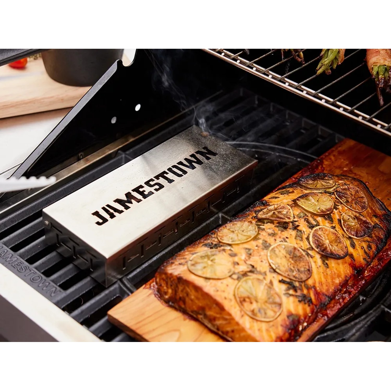 Jamestown Räucherbox aus Edelstahl auf Grill mit Lachs auf Holzbrett. Grillutensil für Raucharoma.