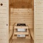 Innenansicht Artsauna Fasssauna Spitzbergen mit Saunaofen und Zubehör.