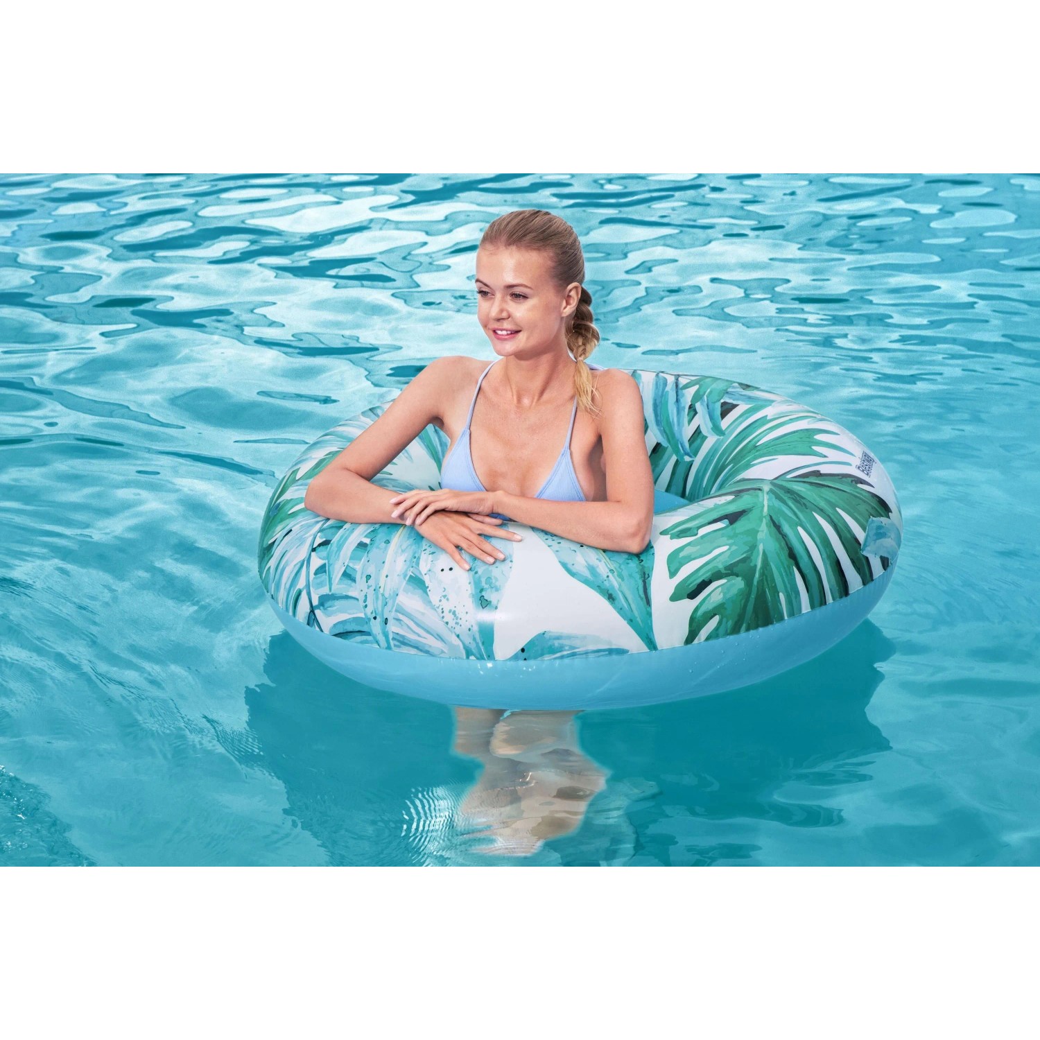 Bestway Schwimmring Tropical Palms im Wasser mit Frau. Luftmatratze mit tropischem Design.