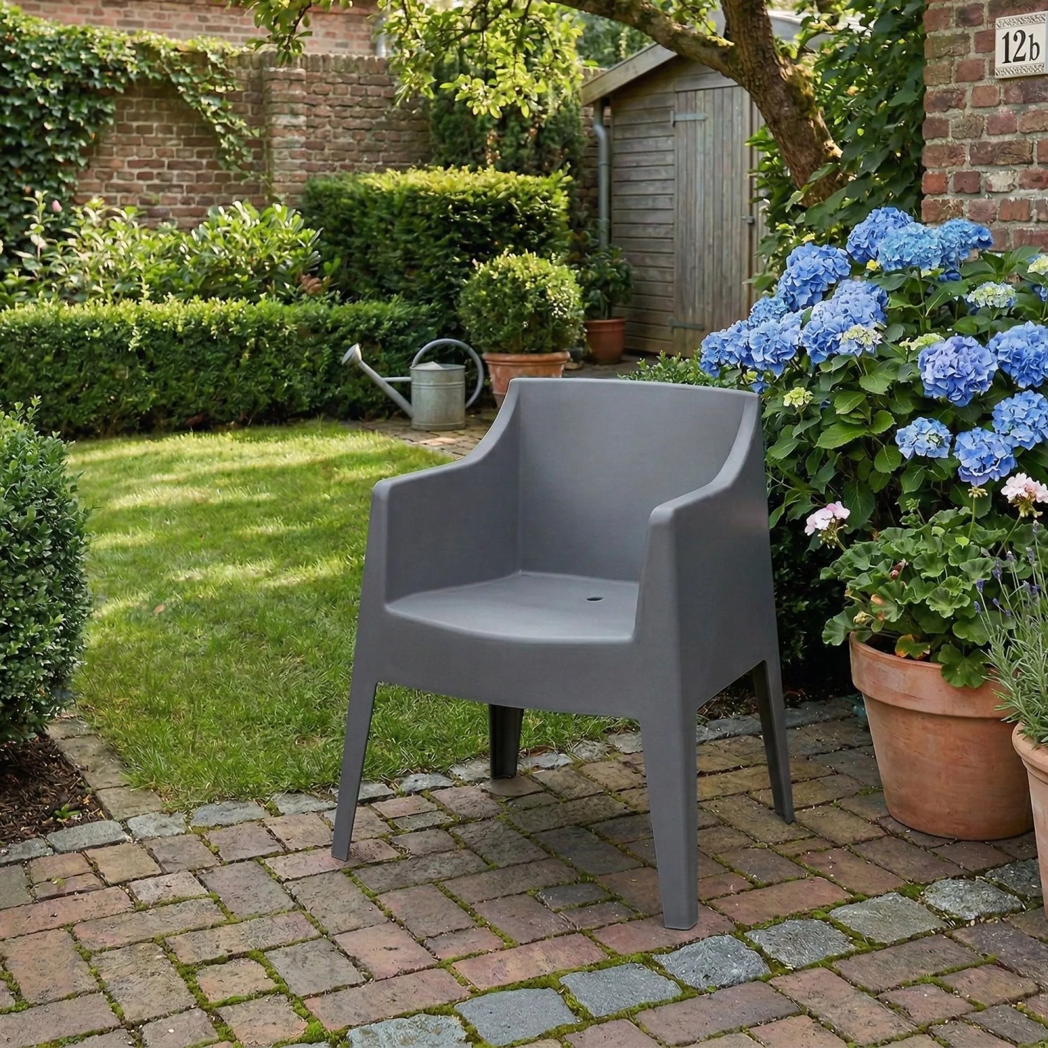 Dunkelgrauer Kunststoff Gartenstuhl Henri, 4er Set, auf Terrasse. Stapelbarer Loungestuhl für Garten & Outdoor.