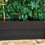 Schwarzer Juliana Pflanzkasten (37x55x95cm) im Garten, ideal für Tomatenzucht im Gewächshaus.