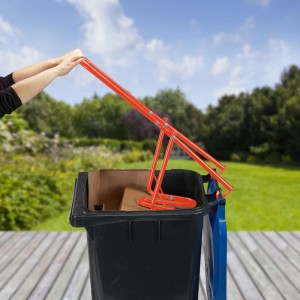 Relaxdays Müllpresse aus Stahl, rot, in Nutzung über einer vollen Mülltonne im Garten.