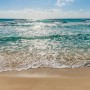 Komar Fototapete Seaside: Strand und türkisfarbenes Meer unter blauem Himmel.