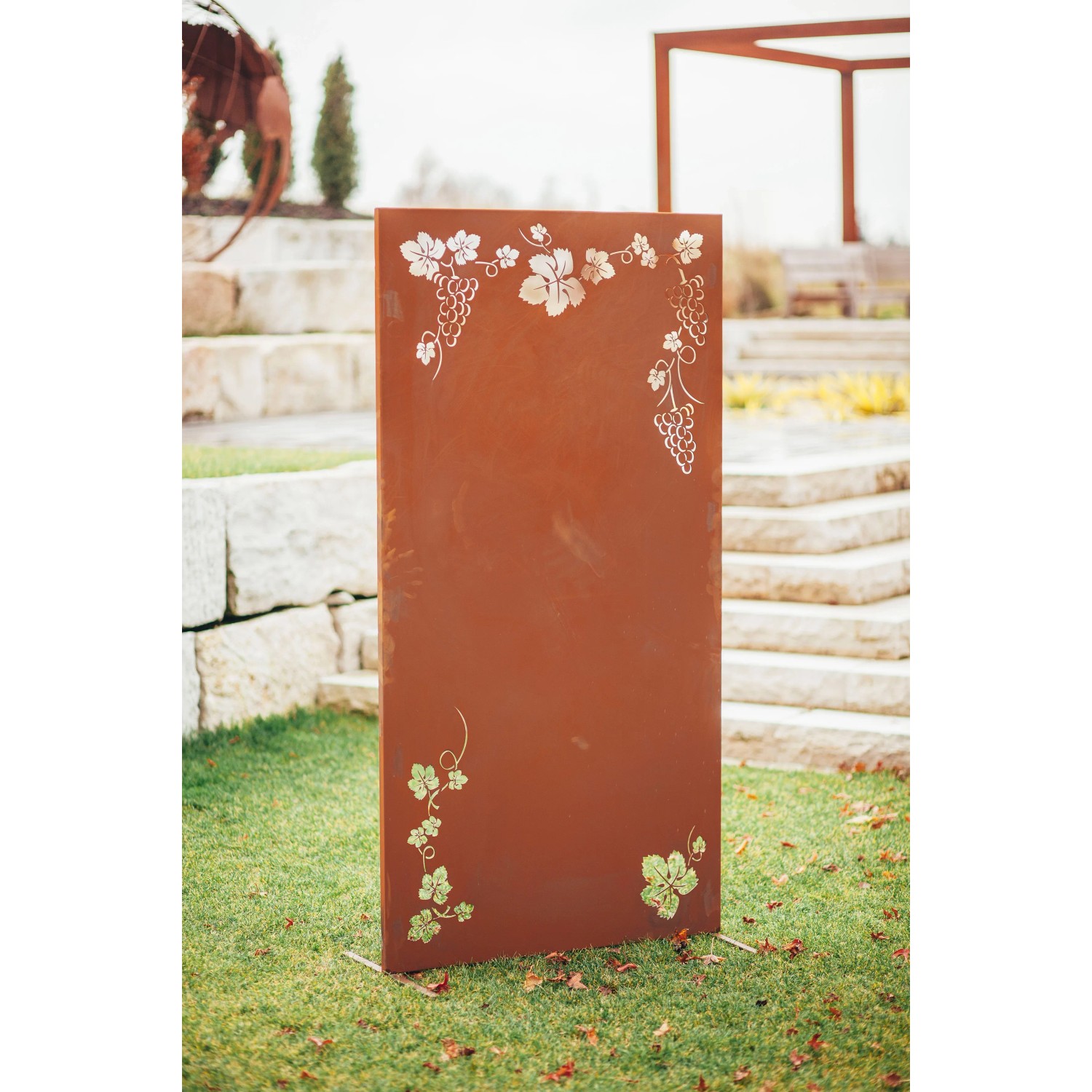 Rostfarbene Sichtschutzwand mit Weinranken-Motiv von Ferrum Art für den Garten.