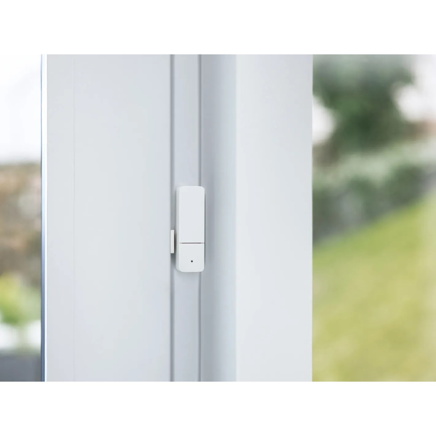 Bosch Smart Home Fenster-/Türsensor II Weiß an einem weißen Fensterrahmen.