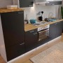 Respekta Küchenzeile 270 cm in Schwarz-Weiß mit Nussbaum Arbeitsplatte und Edelstahlgriffen.