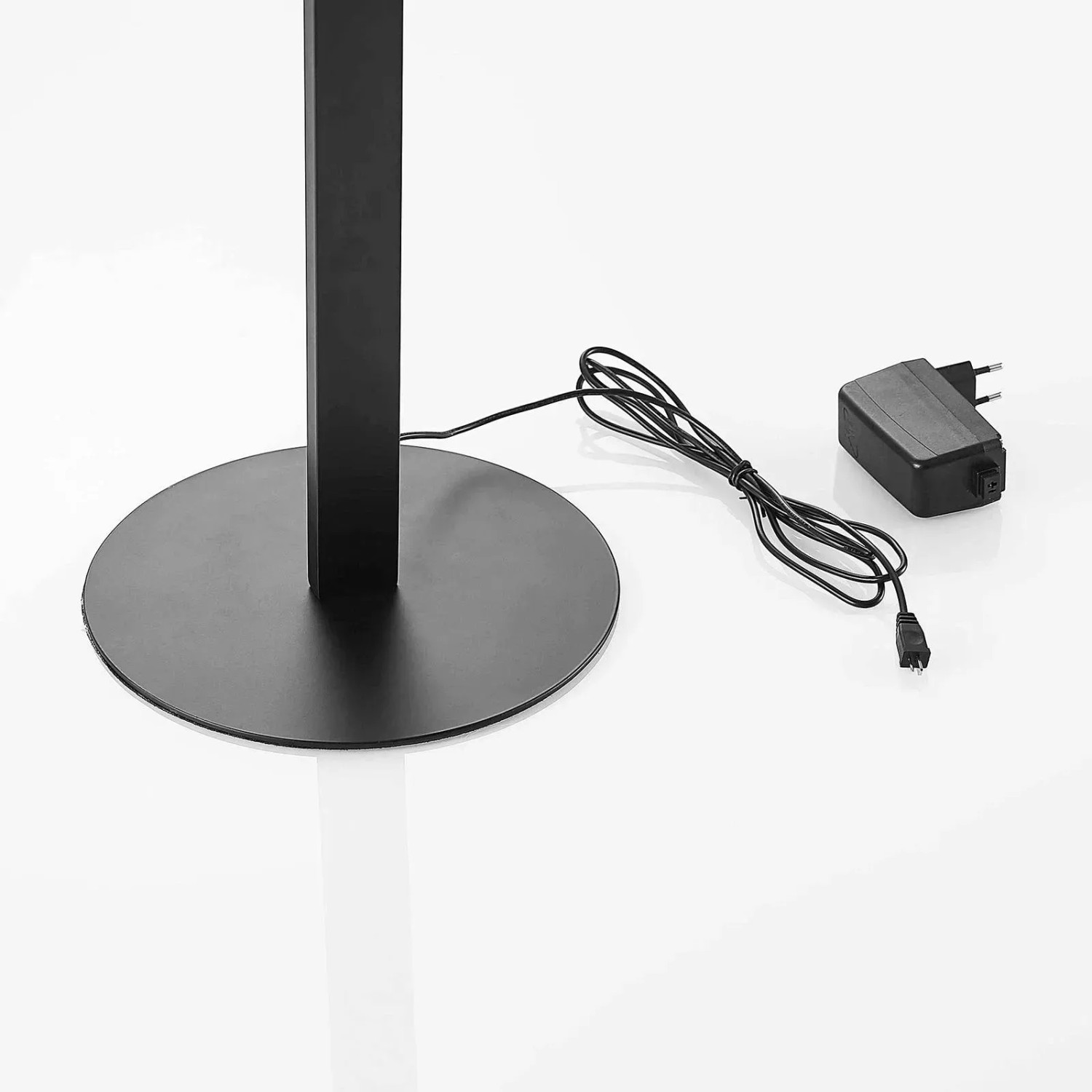 Detailaufnahme der schwarzen Lindby LED Stehlampe Welina mit rundem Fuß und Netzkabel.