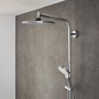 Hansgrohe Crometta Duschsystem mit Kopf- und Handbrause in Chrom/Weiß vor grauer Wand.