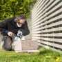 Mann schneidet Stein mit Winkelschleifer, trägt 3M Peltor Gehörschutz und Schutzbrille.