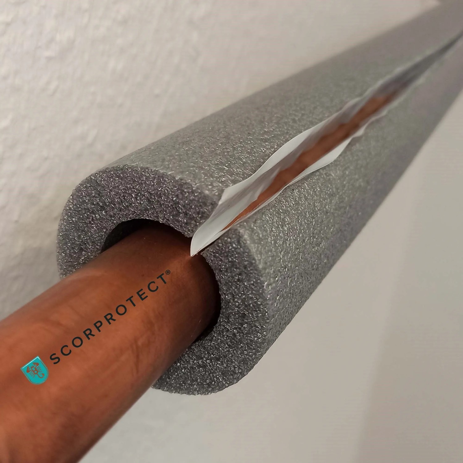 Graue, selbstklebende PE Rohrisolierung (1 m) von Scorprotect, angebracht an einem Rohr.