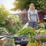 Gardena Haus- und Gartenautomat 3500/4 im Einsatz: Frau bewässert Garten mit Elektro-Pumpe.