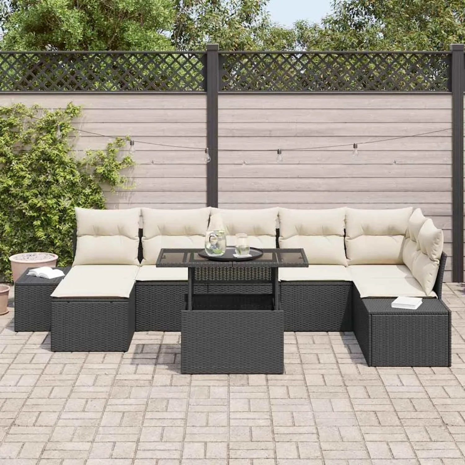 8-teiliges Garten-Sofa-Set aus Poly Rattan in Schwarz mit cremefarbenen Kissen und Tisch.