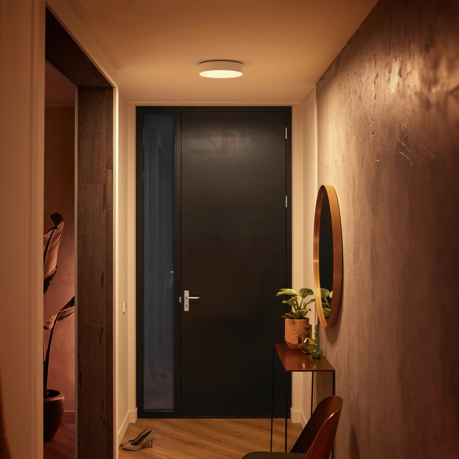 Weiße, runde Philips Hue Enrave Deckenleuchte mit Dimmer im Flur.