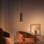 Schwarze Philips Hue Perifo LED-Pendelleuchte als Schienensystem-Erweiterung in Wohnraum-Szene.