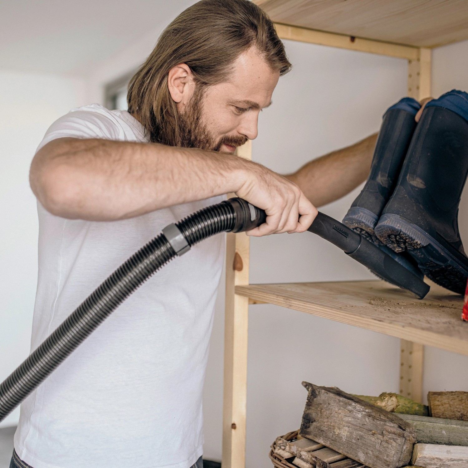 Mann saugt Regal mit Kärcher WD 3 V-17/4/20 Nass-/Trockensauger.