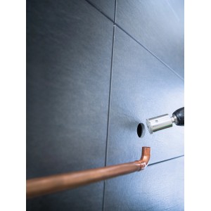 LUX Lochsäge Professional 35 mm beim Bohren eines Lochs in Fliesen für ein Kupferrohr.