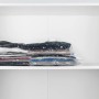 Wenko Vakuumbeutel Set, 6 transparente Aufbewahrungsbeutel mit Kleidung im weißen Schrank.