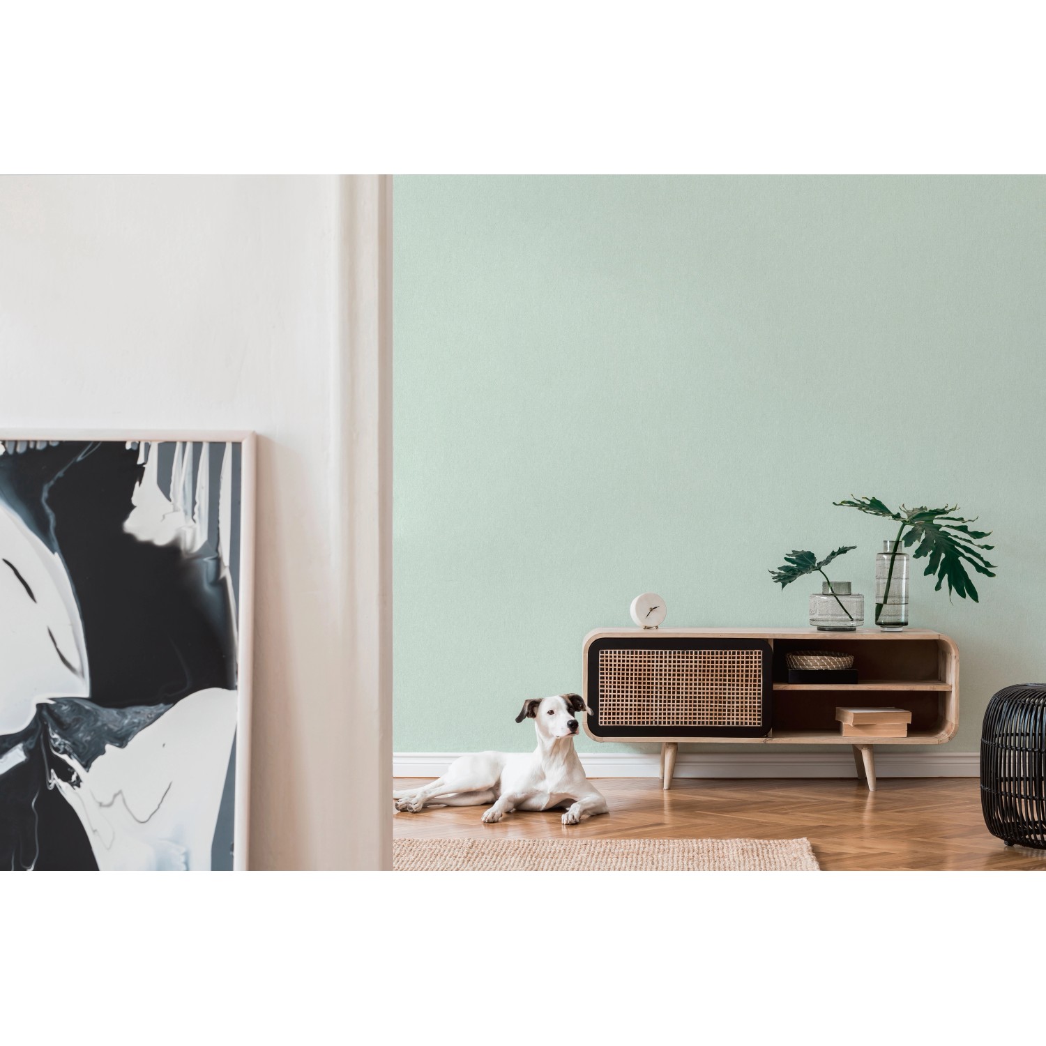 A.S. Création Vliestapete Uni Grün an Wand im Wohnzimmer mit Hund und Kommode.