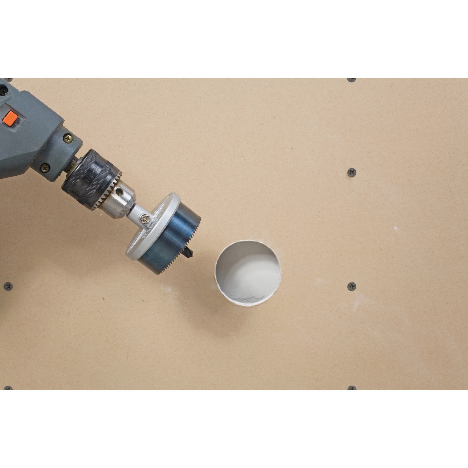 LUX Lochsäge-Set (9-teilig) im Einsatz: Bohren eines Lochs in eine helle Holzplatte.