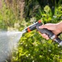 Gardena Premium Reinigungsspritzen-Set im Einsatz: Hand hält Spritze, Wasserstrahl ist sichtbar.
