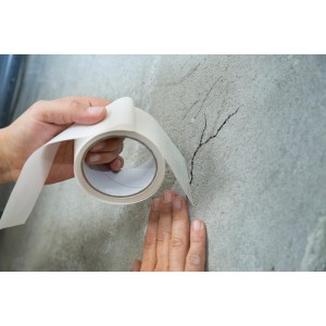 Anwendung der LUX Rissbrücke (10m x 50mm) auf einer Wand mit Riss.