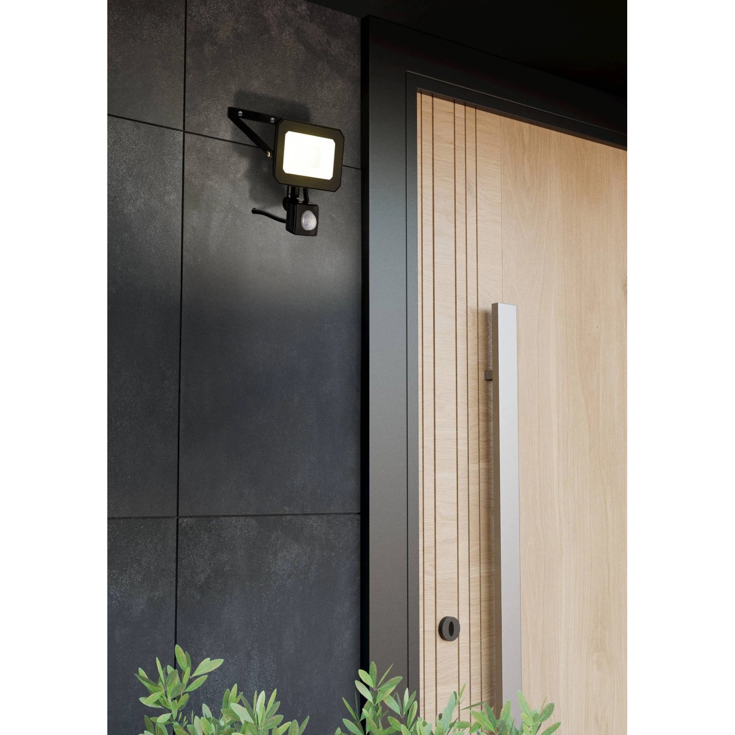 Schwarzer Eglo LED-Wandstrahler Risacca-E mit Sensor an dunkler Hauswand neben einer Haustür.