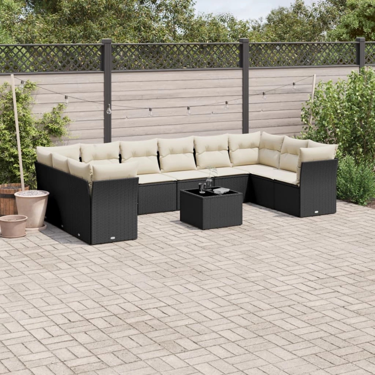 Schwarze 11-tlg. Garten-Sofagarnitur aus Polyrattan mit cremeweißen Kissen und Tisch.