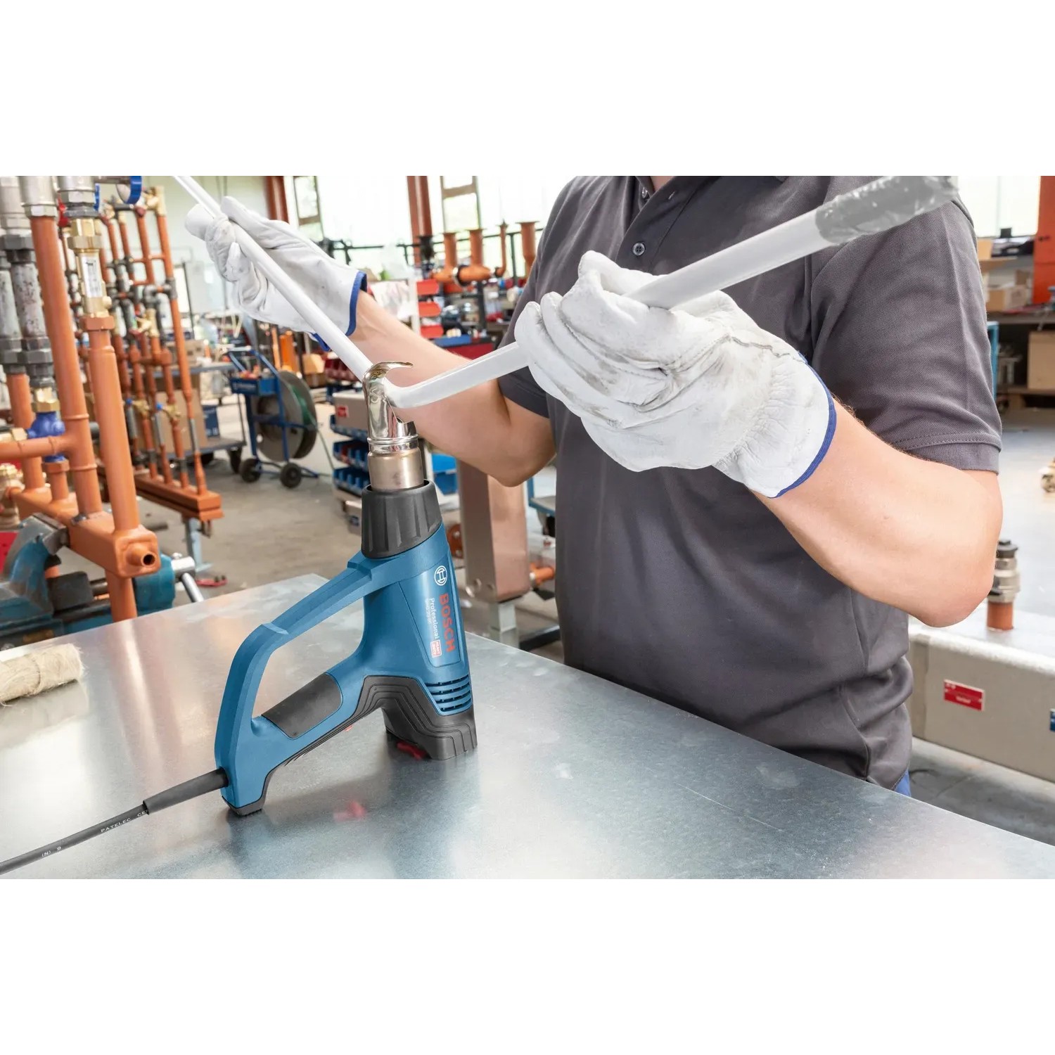 Bosch Professional Heißluftgebläse GHG 23-66 im Einsatz beim Erhitzen eines Rohrs.