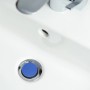 Blauer Sanilo Waschbeckenstöpsel aus Chrom in einem weißen Waschbecken.