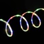 Mehrfarbiges LED Lichtseil (10 m) für Innen und Außen, gewunden auf schwarzem Hintergrund.