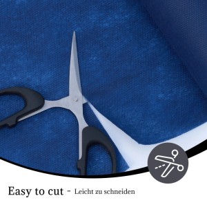 Schere schneidet blaue Vlies Tischdeckenrolle. Einfaches Zuschneiden des flexiblen Materials für Tische.