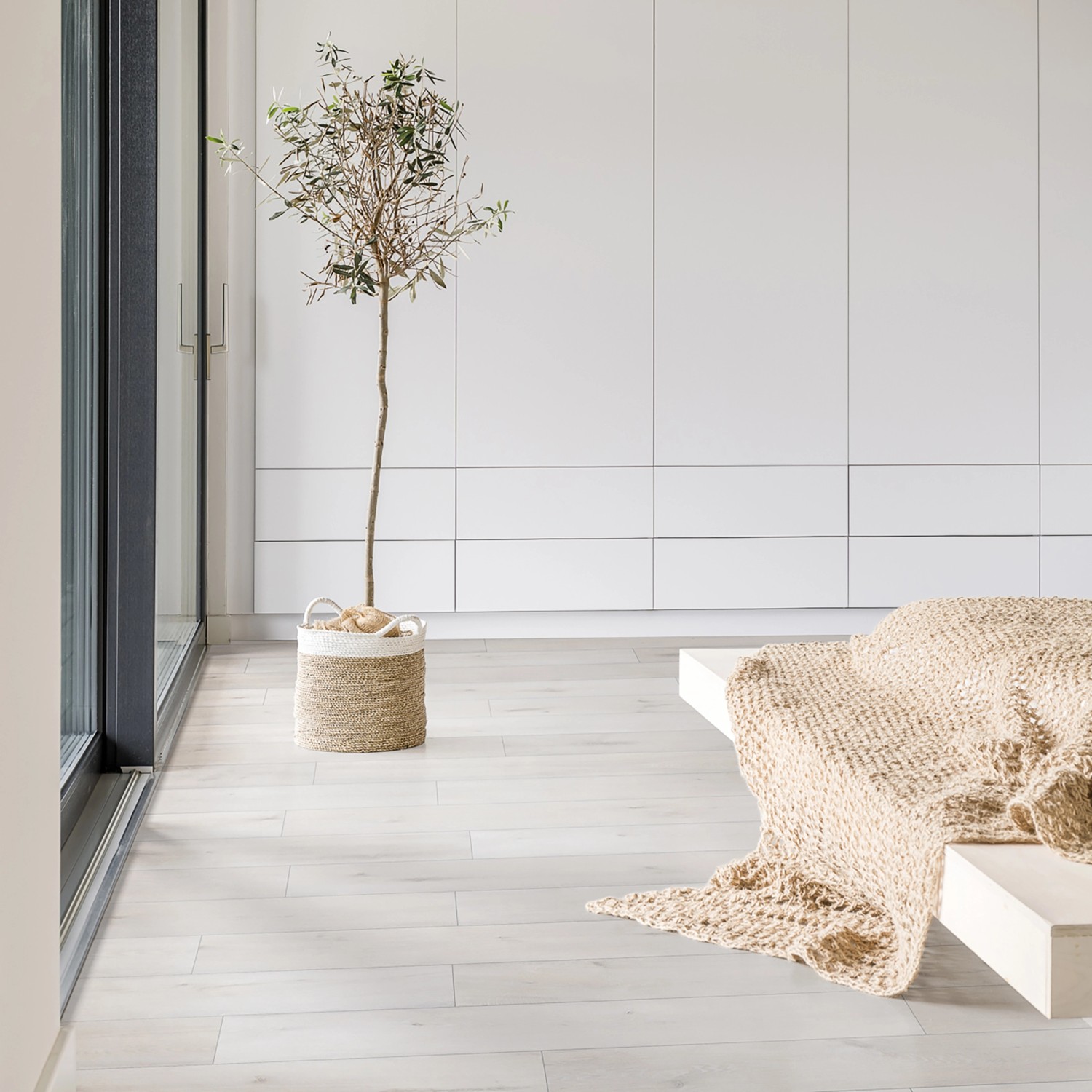 Heller Raum mit Vinylboden Rocko in Holzoptik, Pflanze und beiger Decke.