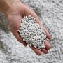 Hand hält weiße Blähtonkugeln für Ecopots Pflanztöpfe, Kategorie: Blumentöpfe.