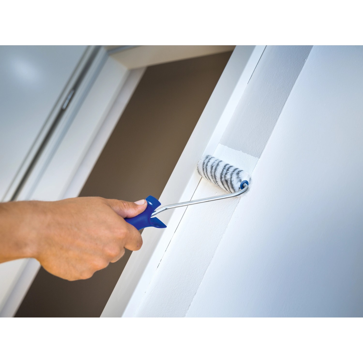 LUX Farbwalze Grau 11 cm im Einsatz beim Streichen einer Wand. Kompakte Farbwalze für kleine Flächen.