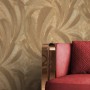 Goldene Vliestapete mit strukturierten Palmenblättern, luxuriöses Design. Ideal für Wohnzimmer, neben rotem Sessel.