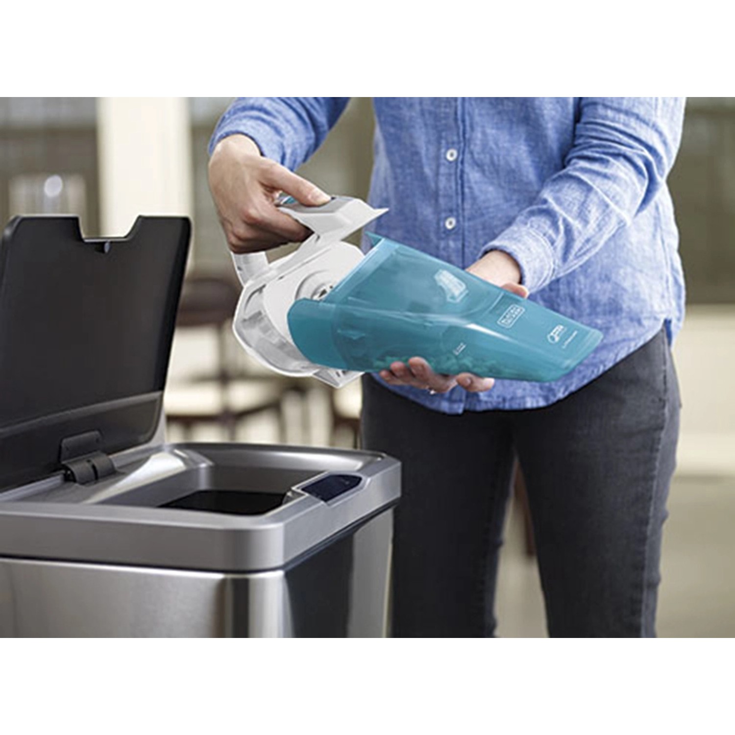 Frau leert den Behälter des Black+Decker Akku-Handstaubsaugers Dustbuster in einen Mülleimer.