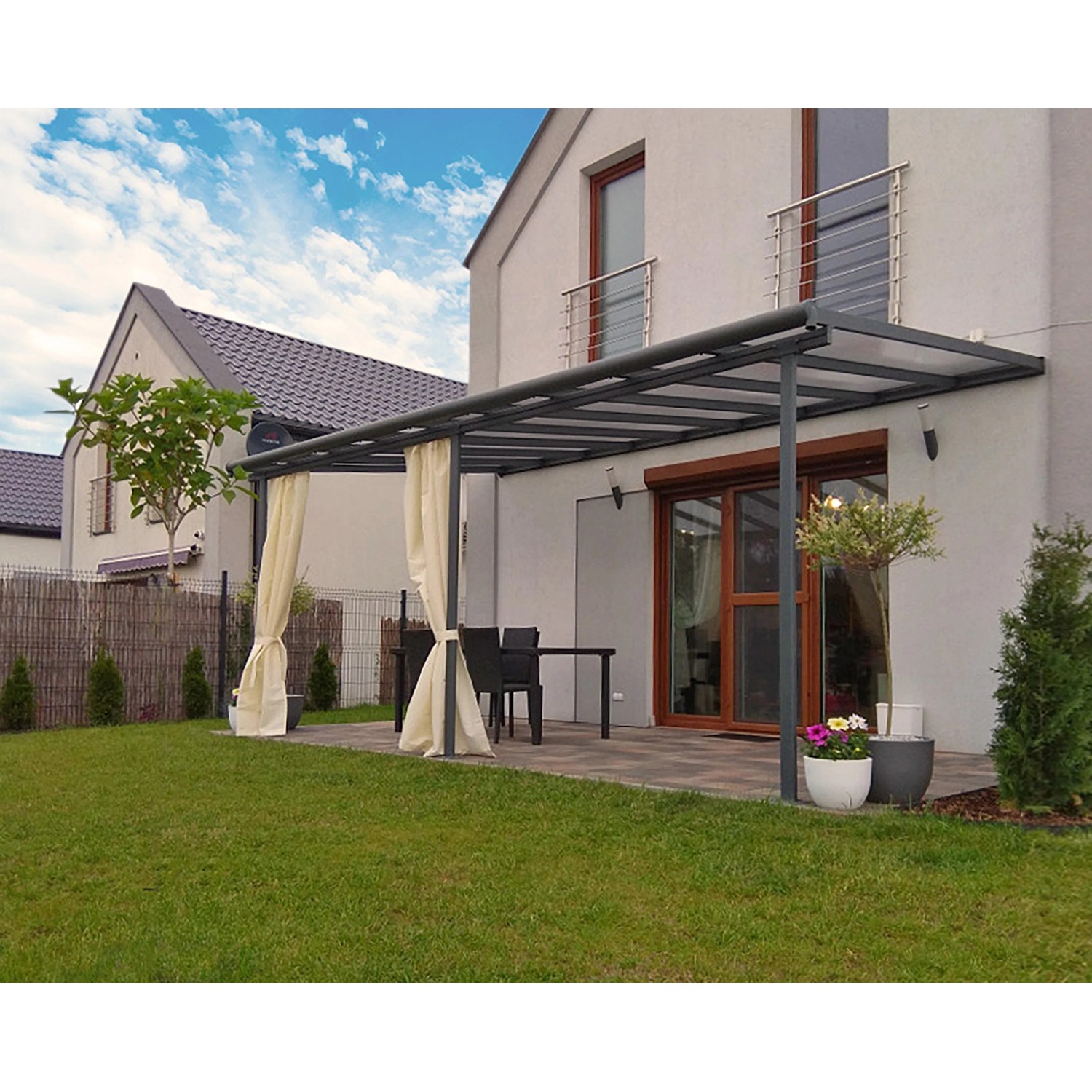 Graue Palram Sierra Terrassenüberdachung (555x295cm) am Haus mit Vorhängen.