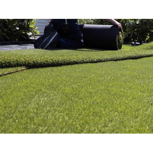 Grüner Primaflor Kunstrasen Arizona, 2x1m, wird ausgerollt. Ideal für Garten, Balkon und Terrasse.
