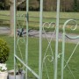 Antik-grüner Metall-Rosenbogen mit Tor, verziert mit Herzen. Robuste Rankhilfe für Rosen und Gartendekoration.