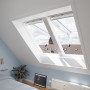 Weißes Velux Klapp-Schwingfenster GPL MK08 im Dachzimmer mit Ausblick.