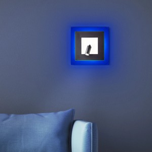 LED-Wandspot Alfie in Weiß/Schwarz mit blauem Rahmenlicht an blauer Wand.