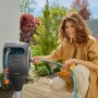 Frau nutzt Gardena Terrassen-Schlauchbox RollUp S mit 15m Gartenschlauch auf Terrasse.