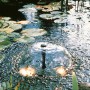 Ubbink Elimax 2500 Springbrunnenpumpe im Gartenteich mit Fontäne und Seerosen.
