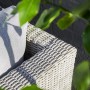 Detailaufnahme: Lounge-Sessel Olea aus Polyrattan in Sand mit hellgrauem Kissen.